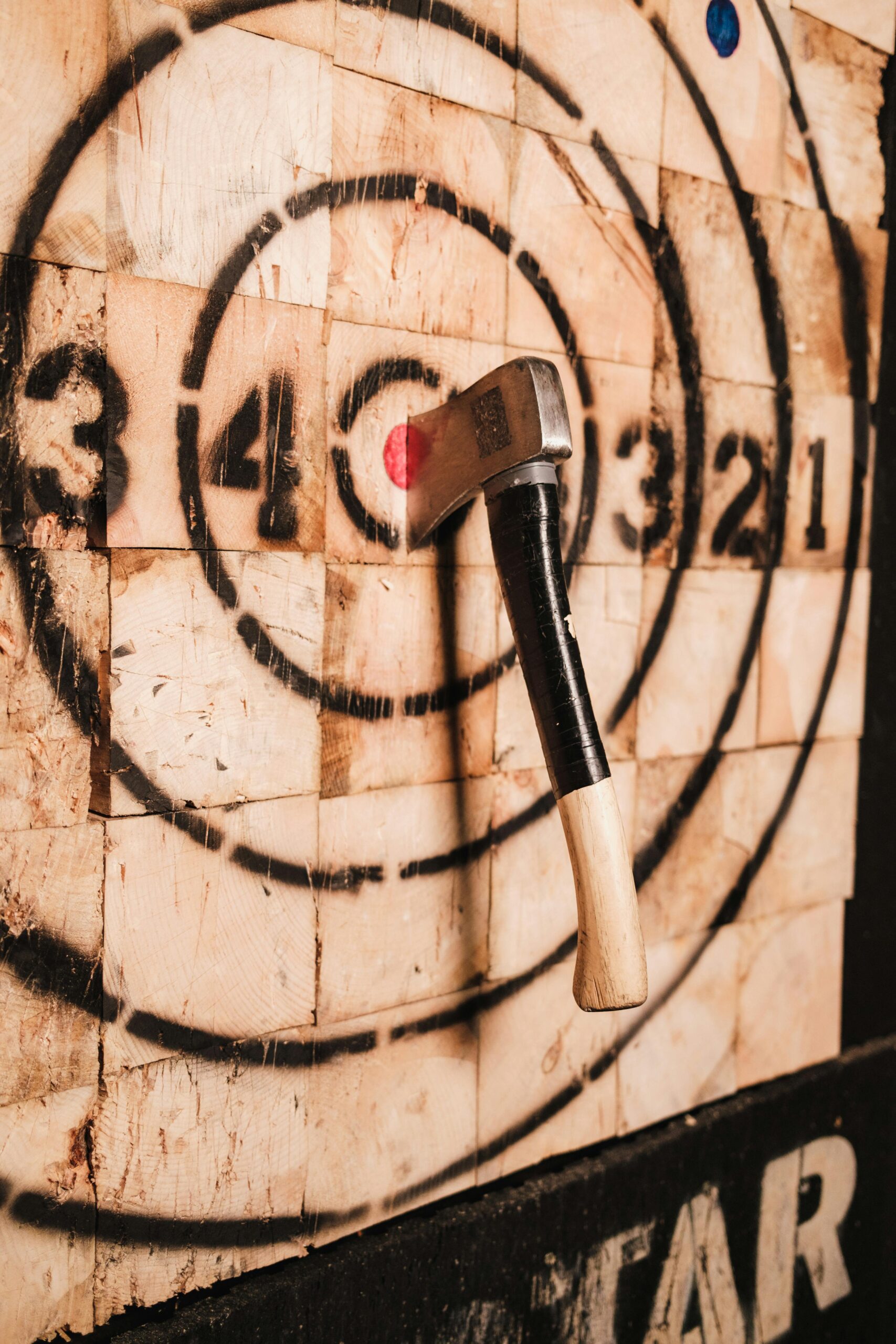 A dramatic close-up of an axe embedded in a wooden target, highlighting precision and skill in axe throwing.