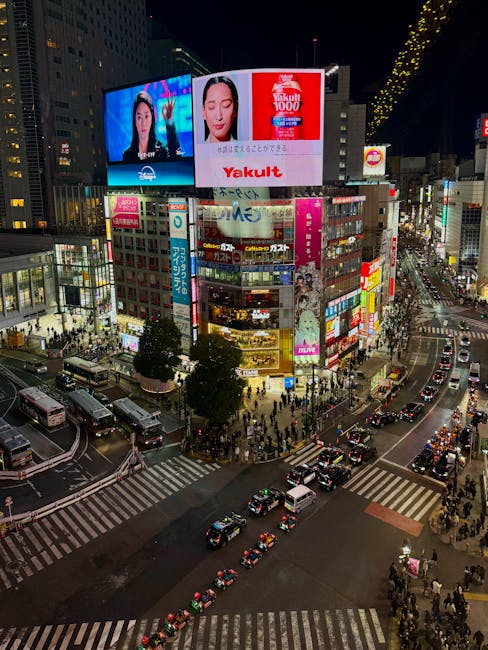 Aerial view of busy Shibuya Crossing in Tokyo at night, vibrant cityscape.