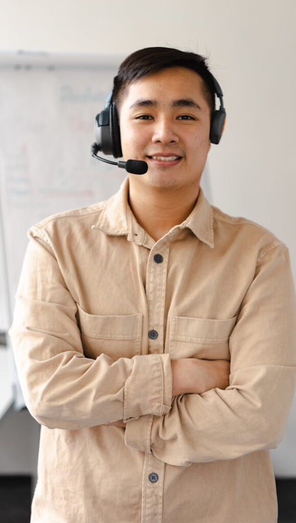 Professional customer service agent smiling while wearing a headset, ready to assist.